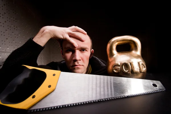 金の saw と重い重量を持つ男 — ストック写真