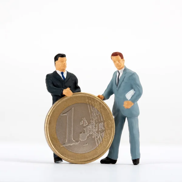Фигуры бизнесменов с монетой в один евро — стоковое фото