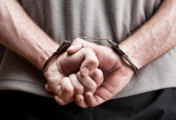 Злочинець в наручники — стокове фото