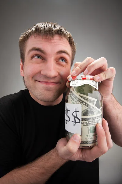 Happy man with canned money — Stock Photo, Image