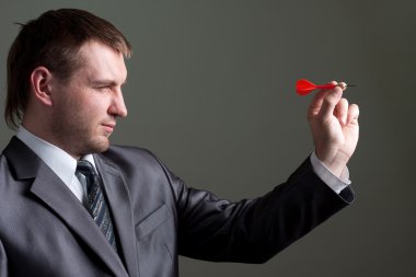 Businessman aiming by dart