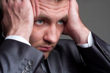 Exhausted sad businessman holding his head clipart