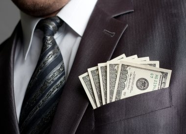 Businessman with money in suit pocket