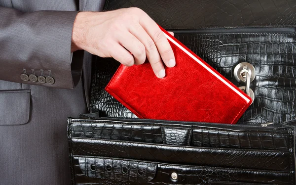 Hand taking red organizer from briefcase — Stock Photo, Image