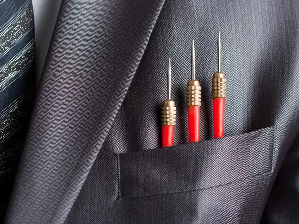Three red darts in businessman suit pocket — Stock Photo, Image