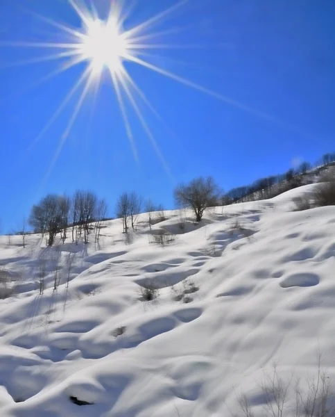 ヘッダーと雪に覆われた山の上の太陽 — ストック写真