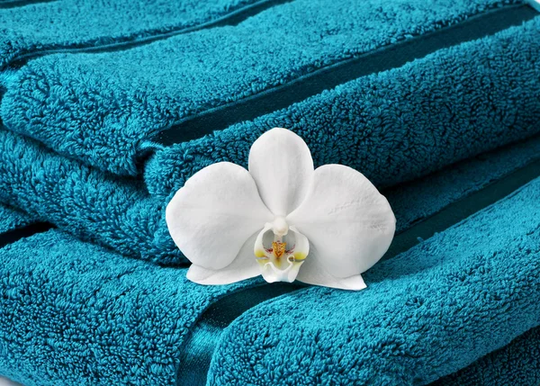 Close up de toalha e orquídea — Fotografia de Stock