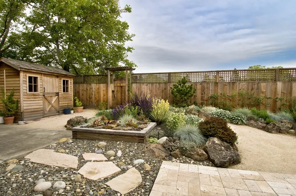小さな木製の小屋 フェンスと経路の美しく手入れされた裏庭 — ストック写真