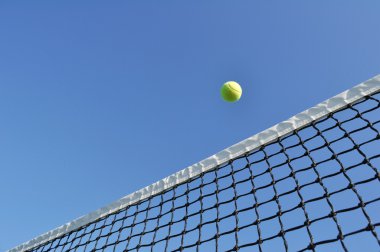 Yellow Tennis Ball Flying Over the Net clipart