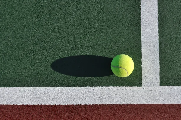 Pelota de tenis amarillo en la pista — Foto de Stock