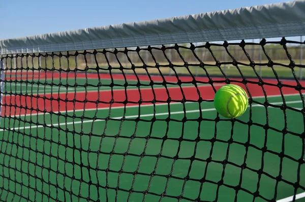 Żółty tenis piłka uderza w sieci — Zdjęcie stockowe