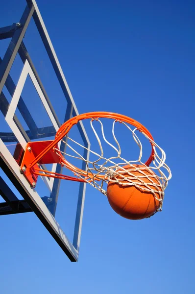 Tiro de baloncesto cayendo a través de la red, cielo azul — Foto de Stock