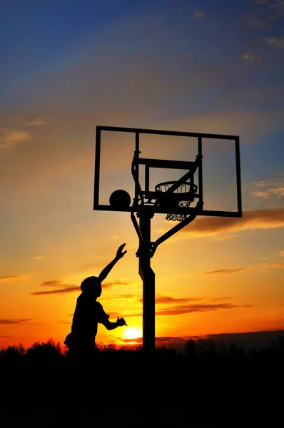 Silhouette de Teen Boy tirant un ballon de basket — Photo