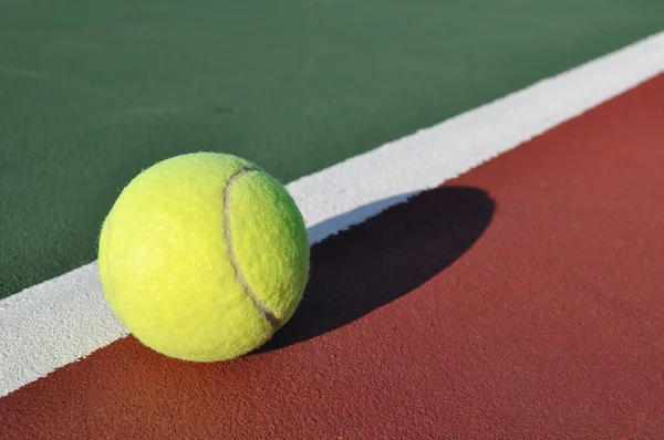Κίτρινο τένις μπάλα στο γήπεδο — Φωτογραφία Αρχείου