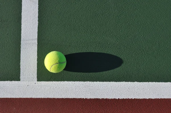 Желтый теннисный мяч на корте — стоковое фото