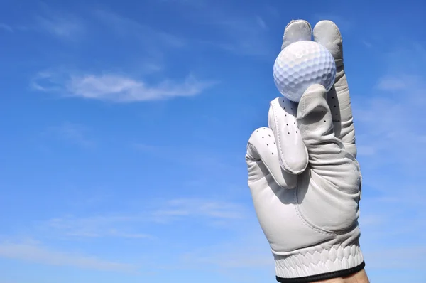 Golfspelare håller en golfboll — Stockfoto