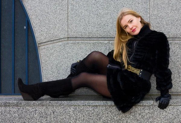 Young Woman Wearing Fur Coat Sitting Wall — Stock Photo, Image