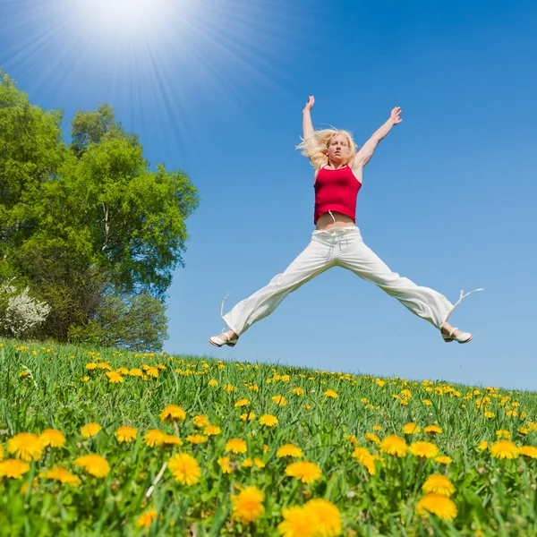 Jovem mulher em roupa vermelha se divertindo no prado — Fotografia de Stock