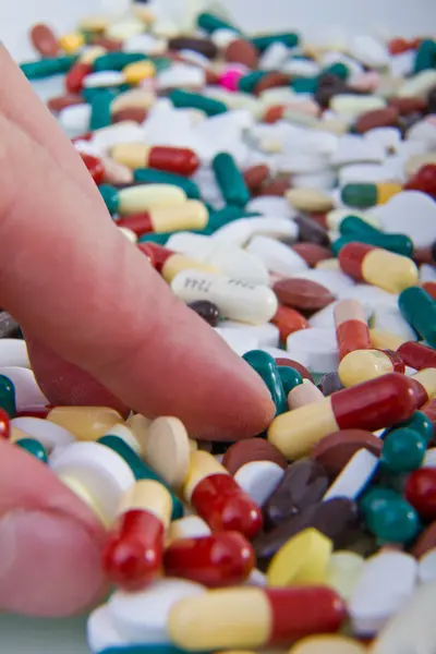 Hand grabbing pills — Stock Photo, Image