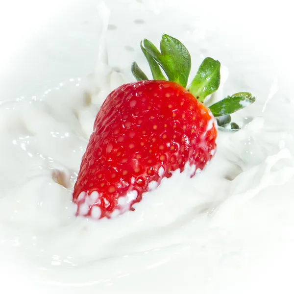 Erdbeere spritzt in Milch — Stockfoto