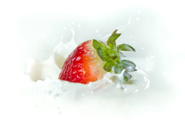 Fresa salpicando en la leche —  Fotos de Stock