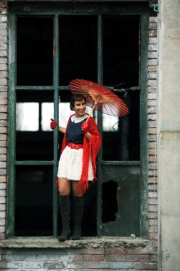 Retro beauty celebrating, with umbrella, in an outdoor location