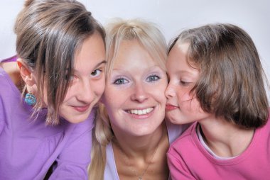 A mother smiles as she receives a kiss on the cheek from her you clipart