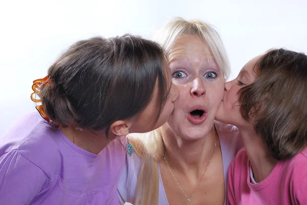 A mother smiles as she receives a kiss on the cheek from her you — Stock Photo, Image