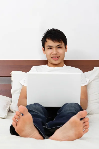 Junge Asiatische Mann Mit Laptop Auf Einem Bett — Stockfoto