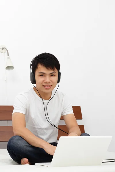Jovem Asiático Com Laptop Fones Ouvido Uma Cama — Fotografia de Stock