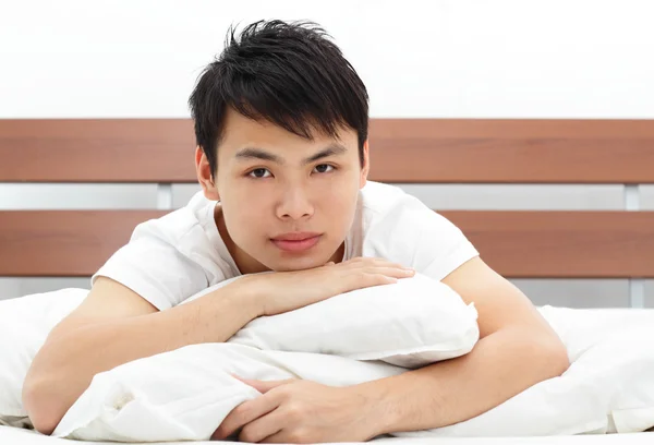 一个亚洲的年轻男子在床上 — 图库照片