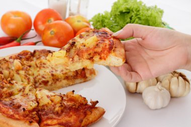 bir dilim pizza tutan bir kadın