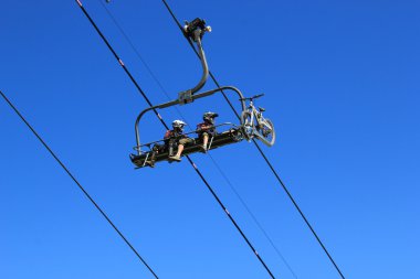 Bikers in a lift in the mountain clipart