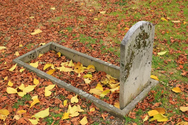 Antigua lápida y hojas de otoño — Foto de Stock