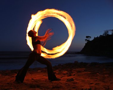 Firedancer along the beach at dusk. clipart