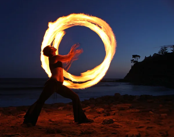 Firedancer wzdłuż plaży o zmierzchu. — Zdjęcie stockowe