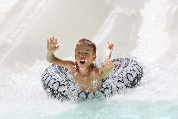 Chico divirtiéndose en parque acuático — Foto de Stock