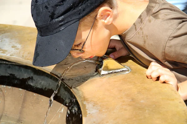 Fiú iszik vizet egy speciális fountain úti — Stock Fotó