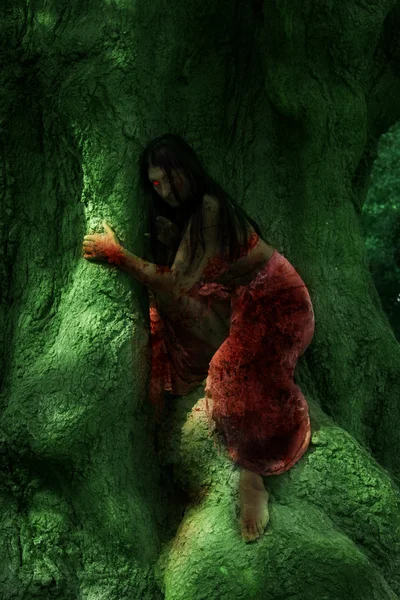 La chica fantástica en un tronco de árbol verde — Foto de Stock