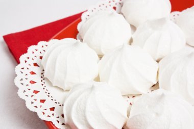 Delicious sweet meringue kiss-cake on red plate clipart