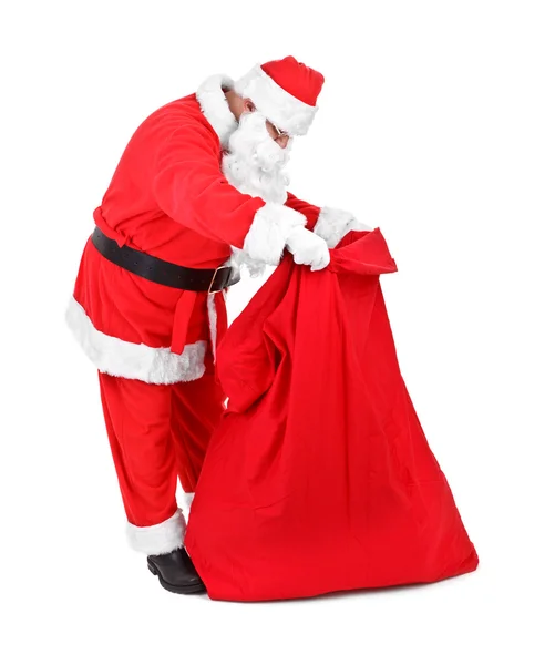Santa claus jest patrząc na prezenty — Zdjęcie stockowe