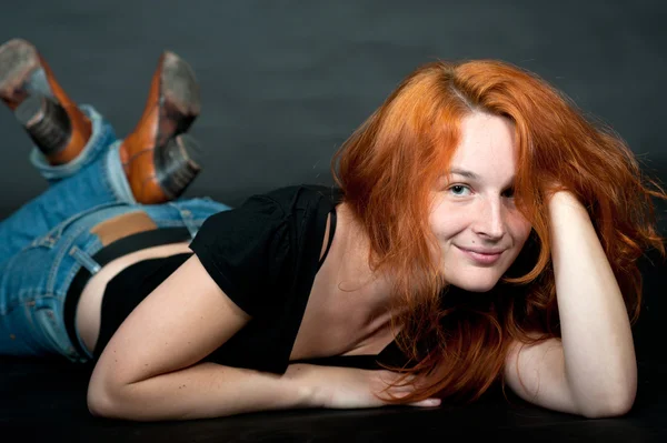 Ung kvinna med rött hår och röda stövlar — Stockfoto