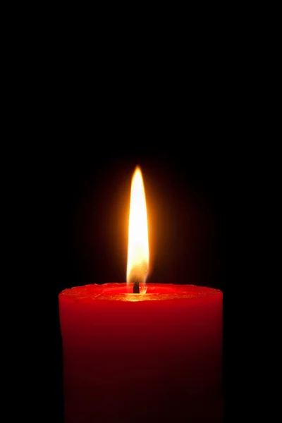Червона свічка перед чорним тлом — стокове фото