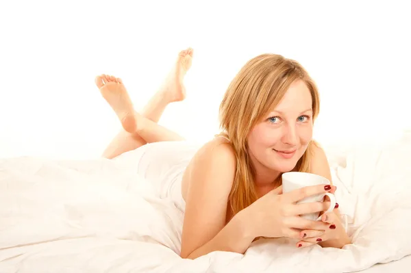 Młoda kobieta picia kawy w łóżku — Zdjęcie stockowe