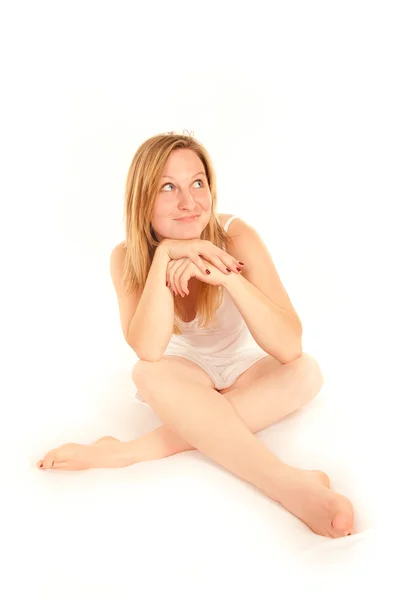 Jonge vrouw op witte bed opzoeken — Stockfoto