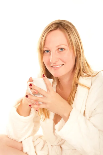 Giovane donna in accappatoio bere caffè a letto — Foto Stock