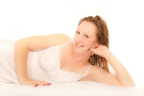 性感年轻女人躺在床上穿白色睡衣 — 图库照片