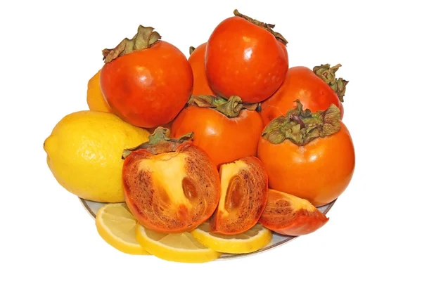 Lemon and persimmon fruit on a platter — Stock Photo, Image