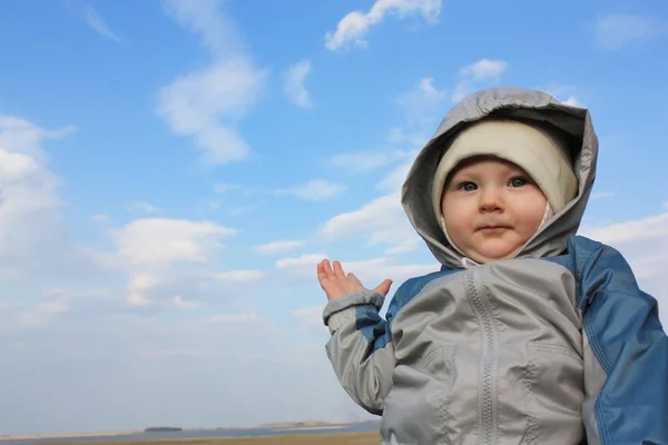 Stock image The kid shows his hand at landscape