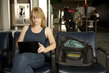 Woman in Airport Using Netbook clipart